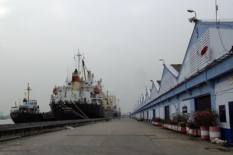 Boats and warehouses along the conventional quays of Bangkok Port. 