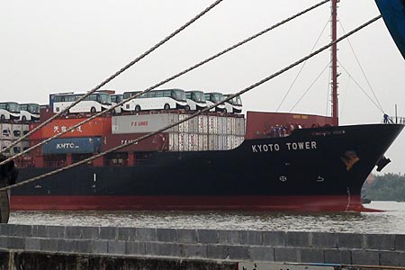 Container transport on the Chao Phraya river. Notice the buses on top of the containers.