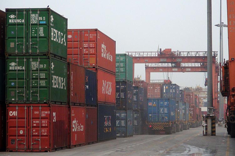 Containers and trucks along the container quay in Bangkok Port